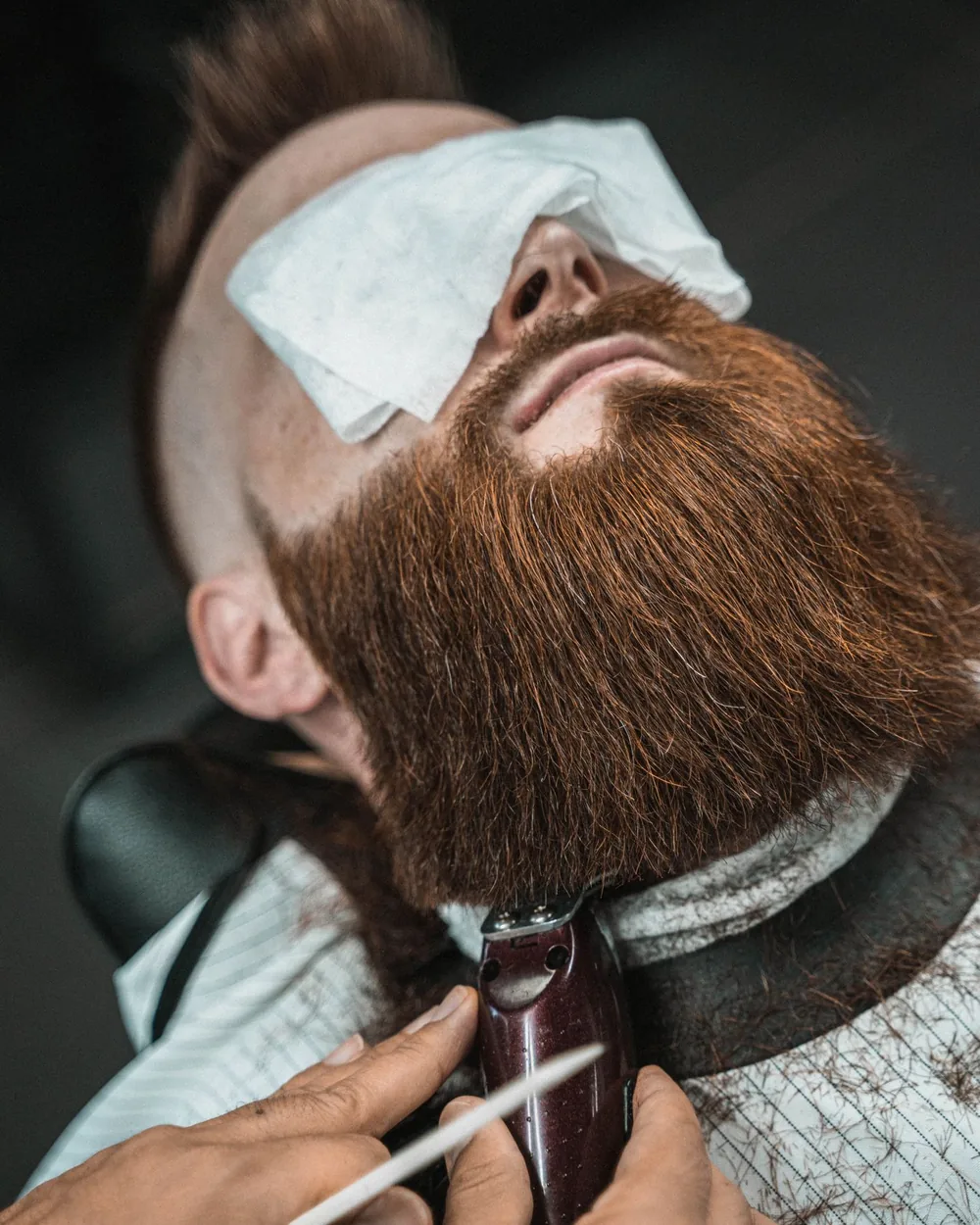 Male client reclined with a hot towel over his face